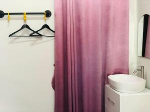 Ban Ton Liangกอบสุข รีสอร์ท2 k04的浴室设有粉红色的淋浴帘和水槽