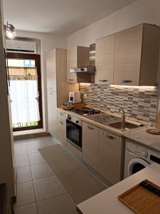 恩纳La casa in piazzetta的厨房配有水槽和炉灶 顶部烤箱