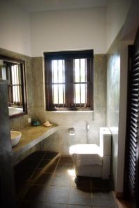 乌纳瓦图纳翠鸟酒店的一间带卫生间、水槽和窗户的浴室