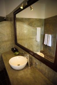 乌纳瓦图纳翠鸟酒店的一间带水槽和镜子的浴室