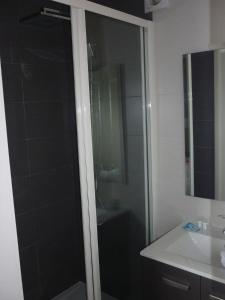 基贝维尔Hotel De La Plage的一间带玻璃淋浴和水槽的浴室