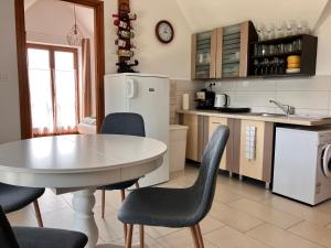 鲍道乔尼特尔代米茨AnnApartman的厨房配有桌椅和白色冰箱。