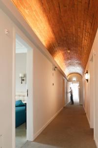 阿威罗若昂派得罗酒店的一条带围墙天花板的走廊,一个男人沿着走廊走