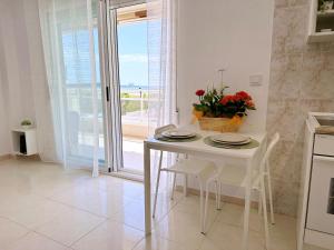 拉皮内达AT-Pineda-03的厨房配有白色的桌椅和窗户