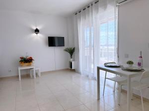 拉皮内达AT-Pineda-03的白色的客厅配有桌子和电视。