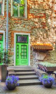 塔林圣奥拉沃酒店的石头建筑的绿色门,有楼梯和鲜花