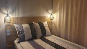 SchashagenCampingland Ostsee - Mobilheim 74Strandzauber NEU!的一间卧室配有一张带两个灯的床