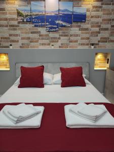 那不勒斯B&B May Dream的一间卧室配有两张带红白色枕头的床