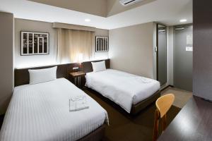京都京都糸屋酒店的一间酒店客房,设有两张床和电视