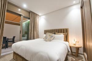 阿加迪尔New Sea Front Apartment 135mq with Unlimited Wi-Fi的卧室配有白色的床和滑动玻璃门