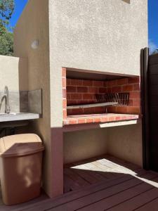 巴尔内阿里奥索利斯Casa para 4 personas en vista24uy, Bella Vista, Maldonado的建筑一侧的砖砌壁炉,设有卫生间