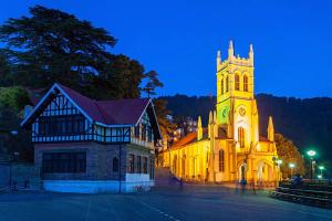 西姆拉Shimla Royale - Near Mall Road Free Pickup From Railway Station Shimla的教堂,晚上有钟楼