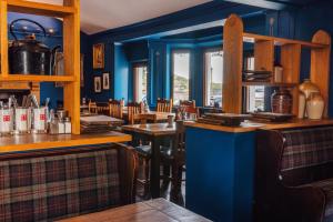 PennyghaelInn at Port nan Gael的餐厅拥有蓝色的墙壁和木制桌椅