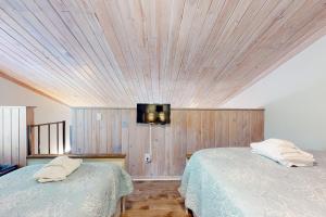 埃迪斯托艾兰Driftwood Villa - 261 Palmetto Perch的一间卧室设有两张床,墙上配有电视。