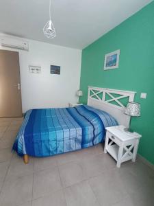 拉隆德莱丝莫里斯L'argentière, proche plage,Résidence piscine, Tennis, parking的一间卧室配有一张蓝色和绿色墙壁的床