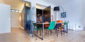 安特卫普B&B - Apartment - Peace in the City的一间带桌子和绿色椅子的用餐室