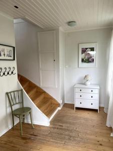 瓦伦蒂纳Charmig villa norr om Stockholm的客房设有楼梯、椅子和梳妆台