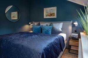 韦斯特兰Backbord的一间蓝色卧室,配有一张床和镜子