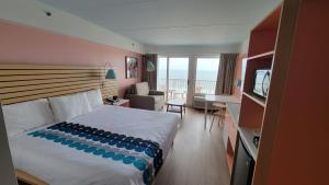 卡罗来纳比奇Golden Sands Oceanfront Hotel的酒店客房配有一张床、一张书桌和一台电视。