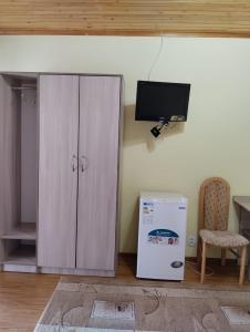 乔尔蓬阿塔В Гостях на Иссык-Куле的白色的橱柜和室内的电视机