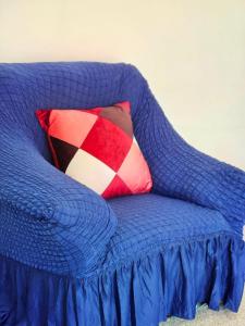 拉格斯Parkside 2 bedrooms appartment with encolsed garden的蓝色的沙发,上面有红色和白色的枕头