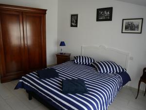 梅尔·莱斯·拜恩斯La Maison Verte 71 m²的卧室配有蓝色和白色条纹床和2个枕头