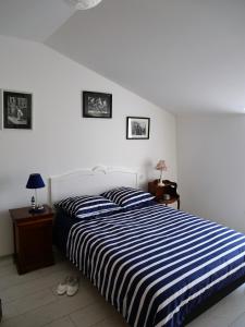 梅尔·莱斯·拜恩斯La Maison Verte 71 m²的一间卧室配有一张带蓝色和白色条纹床单的床