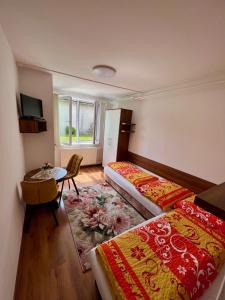 斯祖贝莱克Privat Agnesa的酒店客房设有两张床、一张桌子和一个窗户。