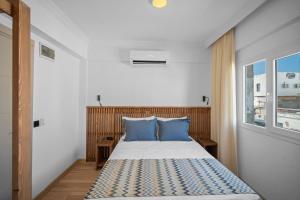 博德鲁姆Costa Viva Bodrum的一间卧室配有一张带蓝色枕头的床和一扇窗户。