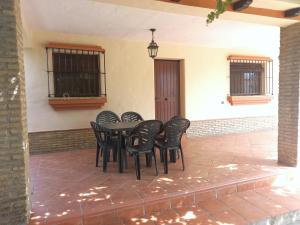 科尼尔-德拉弗龙特拉Casa independiente con piscina - Villa Pintor的天井上摆放着黑色的桌椅