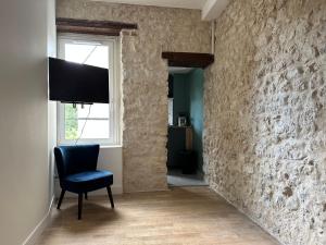 奥尔良Appartement calme design et Comfort的一间房间,配有椅子和带电视的墙壁