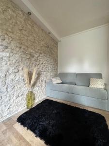奥尔良Appartement calme design et Comfort的客厅设有蓝色的沙发和石墙