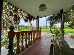 磅湛Toek Chha Temple Resort的一个带木凳和棕榈树的门廊