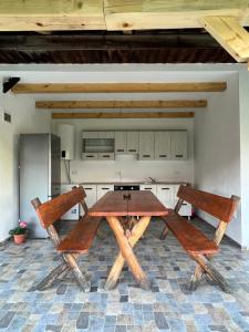 克尔茨什瓦拉乡CASA ANDREI的厨房里配有一张木桌和两把椅子