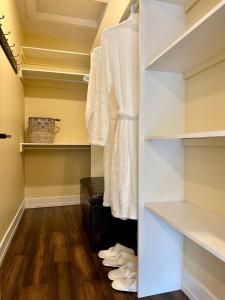夏洛特顿Lotus Moon的步入式衣柜,配有白色的架子和木地板