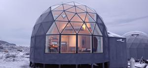 纳塔列斯港Dome with Stunning Glacier & Mountain Views的一间黑色的小房子,设有大型玻璃窗