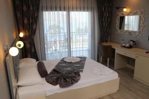 YesilovacıkTOROS DELUXE RESORT HOTEL的一间卧室配有一张床、一张书桌和一个窗户。