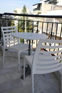 Néa KhilíStuDio 57(10)的阳台上配有两把白色椅子和一张桌子