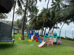 马塞约Jatiuca Suítes Resort FLAT的草地上运动场,有五颜六色的游戏设备