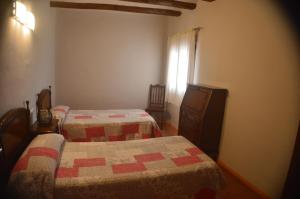巴尔铁拉Casa Rural El Convento的一间卧室设有两张床,其中设有窗户。