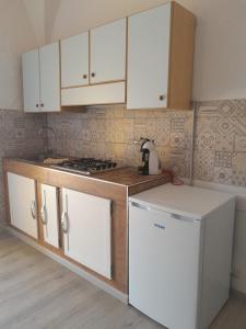皮昂比诺Casa vicino al mare的厨房配有白色橱柜、炉灶和冰箱。
