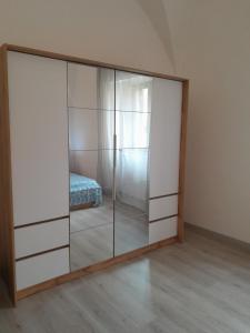 皮昂比诺Casa vicino al mare的一个带玻璃门的衣柜,位于带一张床的房间