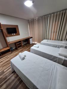 皮拉尼亚斯Hotel Reserva do Xingó的酒店客房设有两张床和一台平面电视。