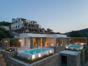 安德罗斯Casa Di Fiori Andros Suites的一座带游泳池和大楼的房子
