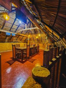 达瓦拉维Hasthi Safari Cottage的大楼内带桌椅的用餐室