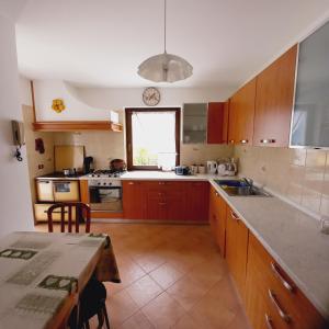 MassimenoAPPARTAMENTO OLGA的厨房配有木制橱柜、桌子和窗户。