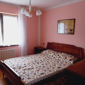 MassimenoAPPARTAMENTO OLGA的卧室内的一张床位,卧室设有粉红色的墙壁和窗户