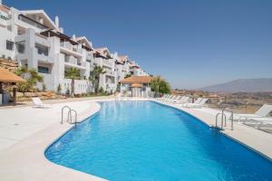 卡拉德米哈斯Calita 109 Mijas Costa - Málaga的一座带椅子的度假村的游泳池和一座建筑