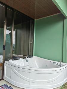 福尔图纳Encanto Arenal lodge的一个带镜子的房间内的大白色浴缸