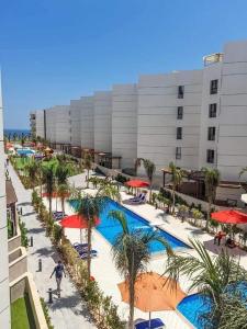 塞得港Porto said的一座拥有游泳池、棕榈树和建筑的酒店